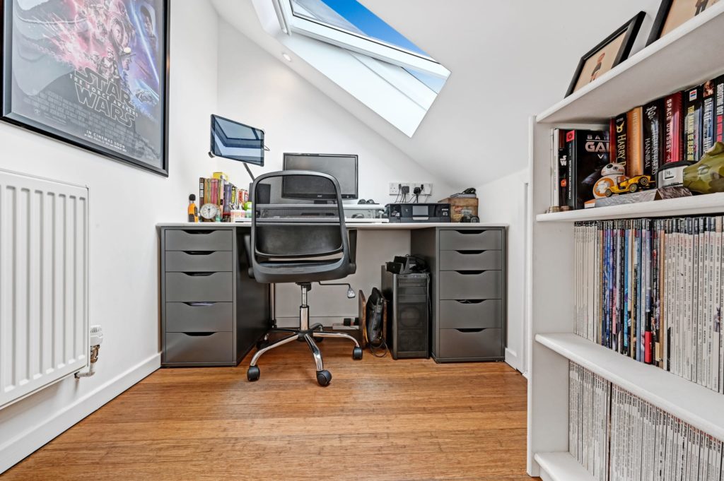 home office loft conversion with wood floor and large skylight